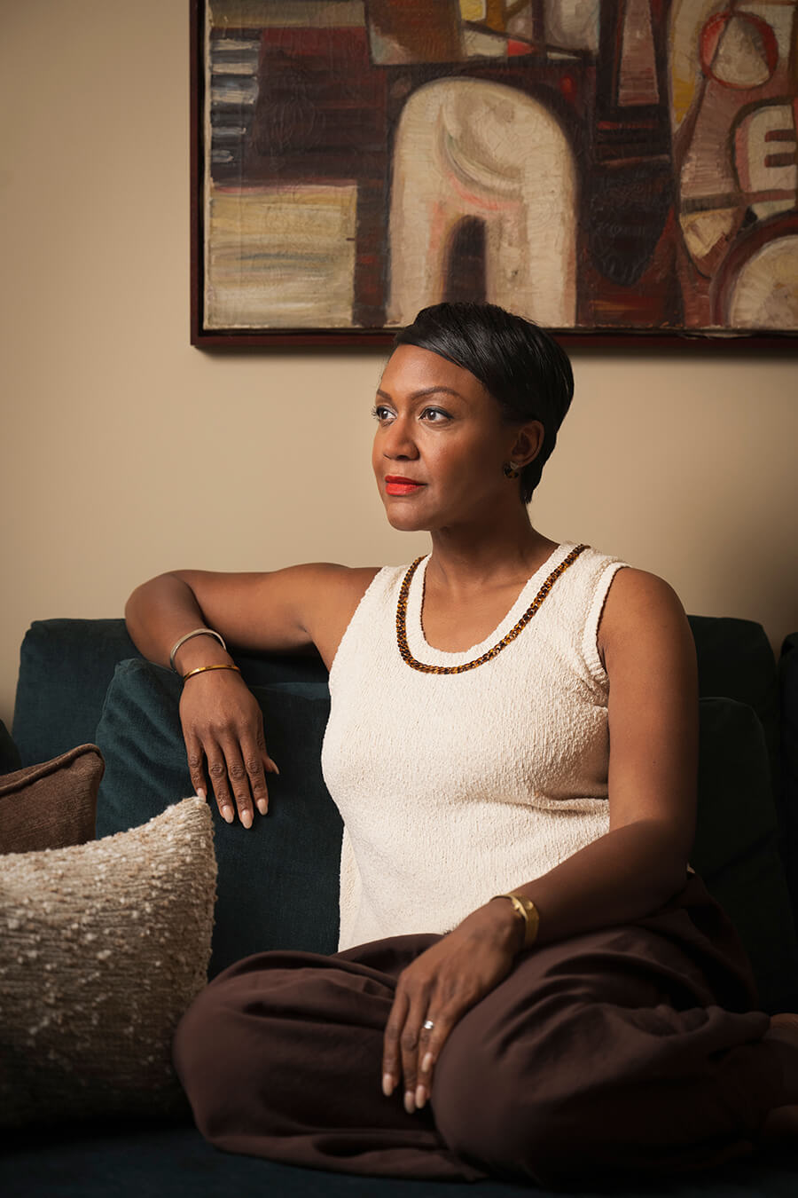 Interiors expert Alex Dauley seated in her London home with African-inspired fine art hung on the wall.