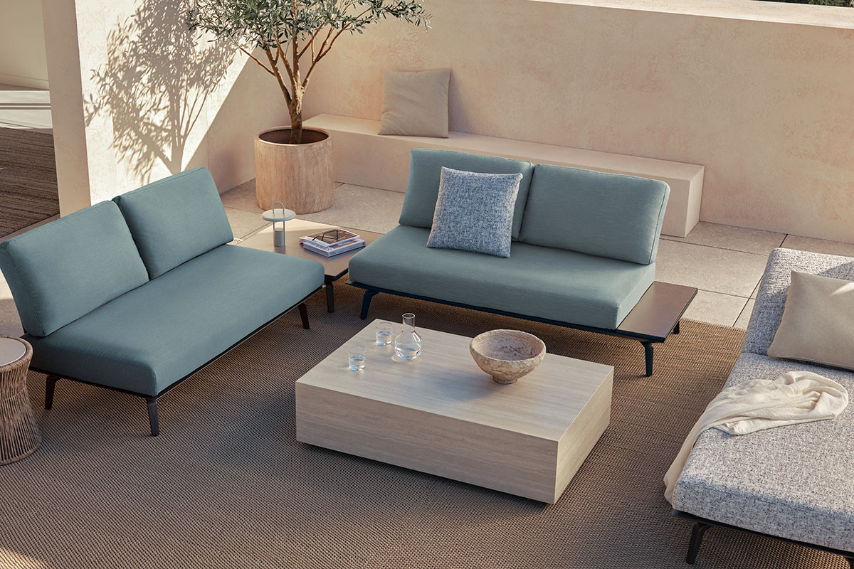 King Cove outdoor seating in Meridian fabric, arranged around a low coffee table on a shaded terrace.