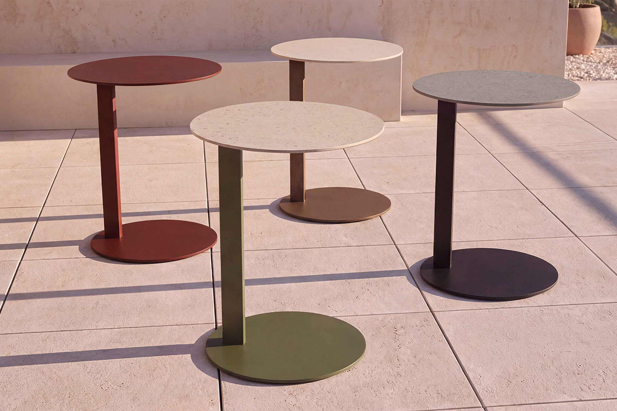 Myco Side Tables in a range of KingCote<sup>®</sup> finishes, including Russet and Eucalypt, arranged on a sunlit outdoor terrace.