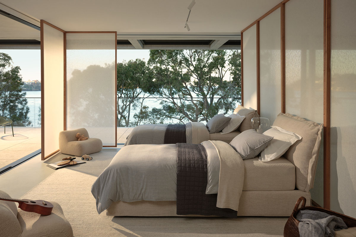 Two king single size beds with a relaxed, coastal aesthetic styled in a twin children’s bedroom with blue linen bedding.